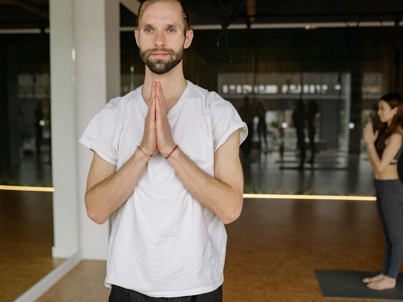 Person in a focused yoga pose in a modern studio.